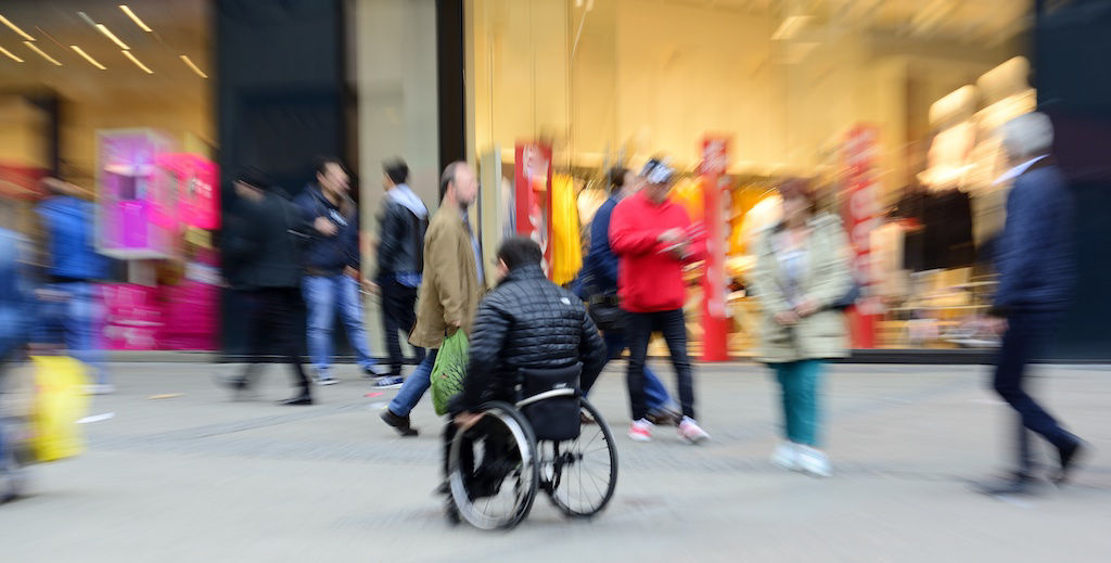Man in wheelchair among shoppers on busy Chicago street